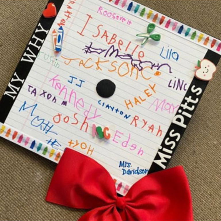 Mortarboard decorated by a student teacher with the names of her students in different colors.